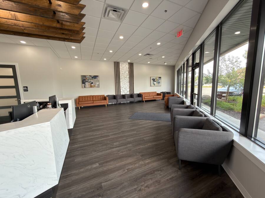 Waiting area with leather seating and floor-to-ceiling windows at the Greenfield office