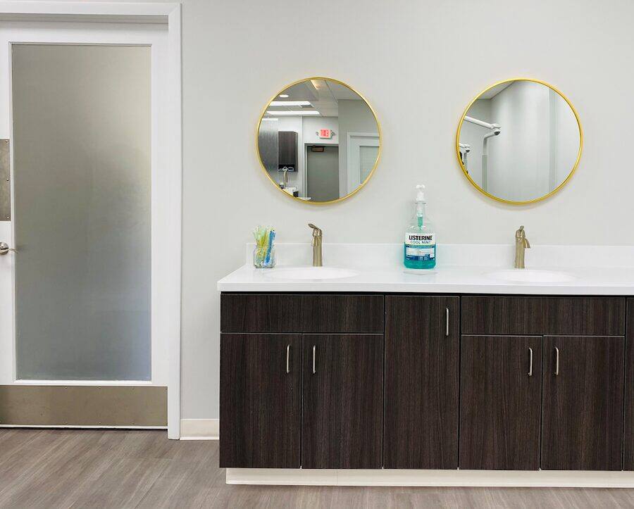 Patient hand-washing station with round mirrors at the Milwaukee office